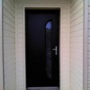Porte d'entrée en alu noir sur maison en bois